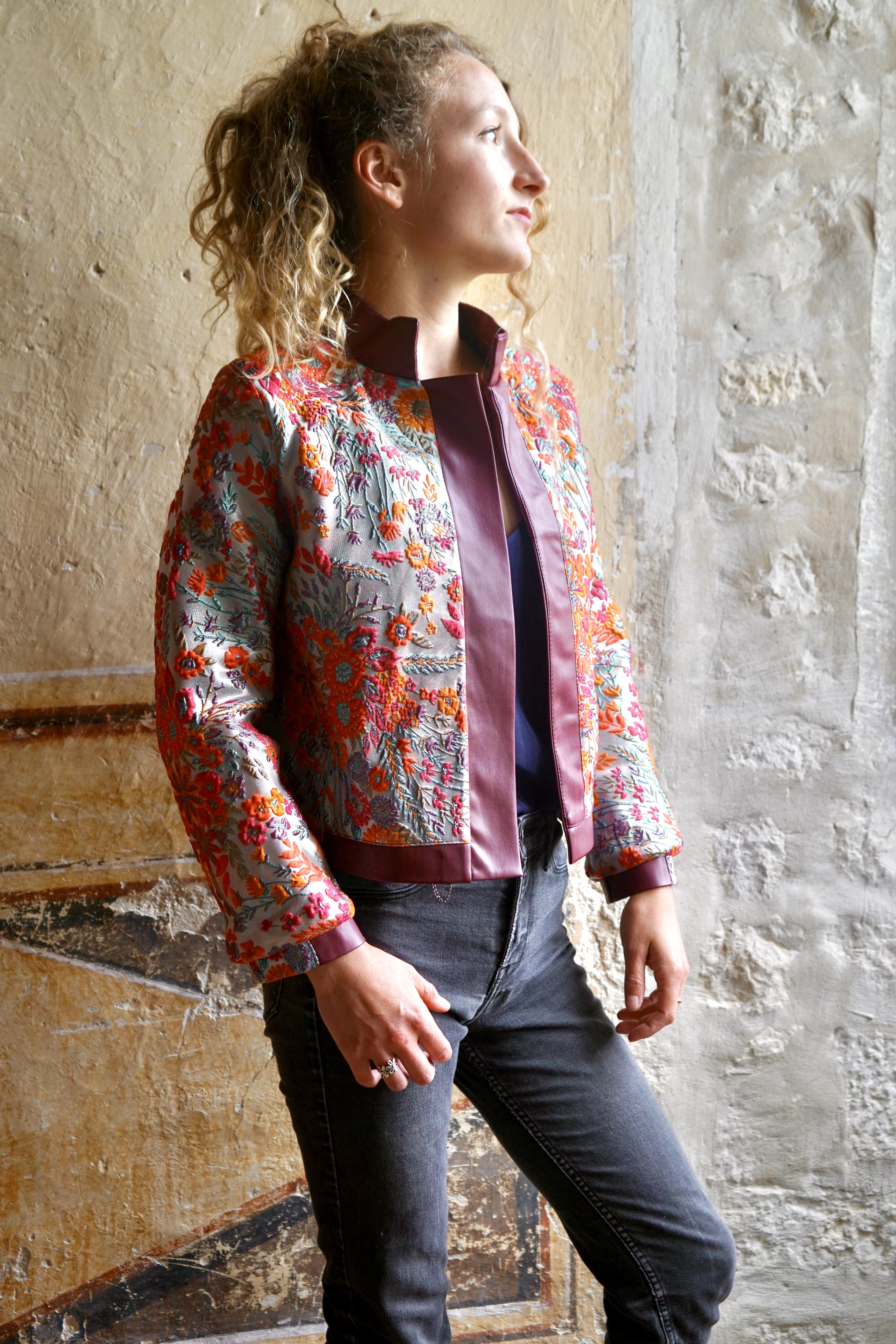 Model wearing jacket inside out to show flowery lining
